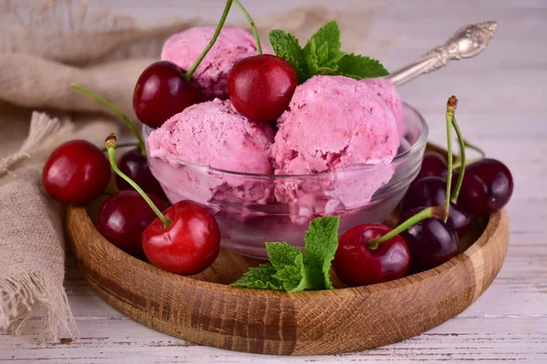 Cherry ice cream in a glass bowl and fresh cherries.Close-up.