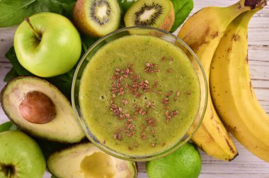 Keten tohumlu bir bardak sağlıklı yeşil smoothie. Yakın plan. Düz yatıyordu.