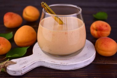 Kayısı suyu koyu bir arka planda bir bardakta. Yakın plan..