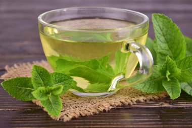 Koyu ahşap arka planda bir fincan nane çayı. Yakın plan. Seçici odak.