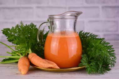 Carrot juice in a carafe. Juice rich in vitamin A. clipart