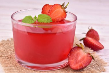 Beyaz arka planda bir bardakta çilek reçeli. Yakın plan..