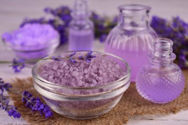 Kâsede lavanta banyosu tuzu, lavanta çiçekleri, aroma yağı, fincanda yüz serumu doğal bitkisel ilaçlar, aromaterapi konsepti..