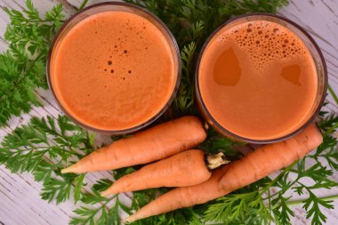 Bardakta havuç suyu, taze havuç. Yakın plan. Düz yatıyordu.