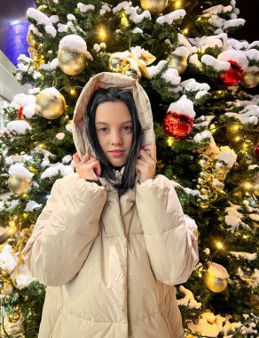 Yeni yıl ağacına yakın bir kız kışın açık havada ve arkasında Nears öznitelikleri ile