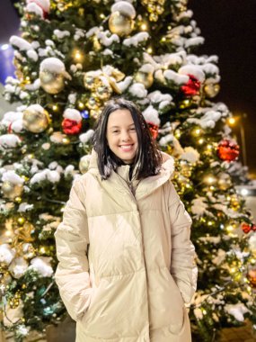 Yeni yıl ağacına yakın bir kız kışın açık havada ve arkasında Nears öznitelikleri ile