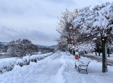Przemysl, Polonya 'da güpegündüz yapılan kar yağışı altında seti ve seti gören karla kaplı bank.