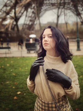 Lady near Eiffel Tower in Paris, France was made in winter. No snow, only some rain on the street. 