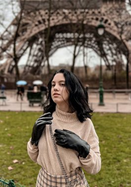 Lady near Eiffel Tower in Paris, France was made in winter. No snow, only some rain on the street. 
