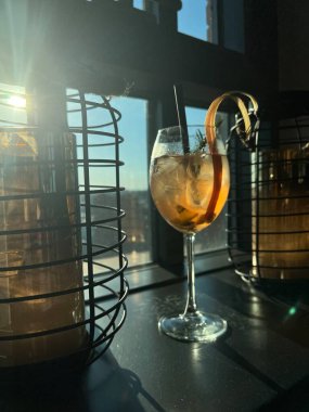 Bir kafede, bir bardakta kokteyl. Pencereden gelen güneşin gölgeleri.