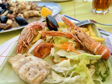 Izgara karides ve salatalı midye. Masada karides ve midye olan lezzetli deniz ürünleri salatası.