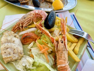 Izgara karides ve salatalı midye. Masada karides ve midye olan lezzetli deniz ürünleri salatası.