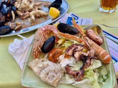 Izgara karides ve salatalı midye. Masada karides ve midye olan lezzetli deniz ürünleri salatası.