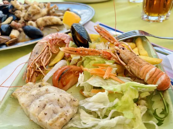 Izgara karides ve salatalı midye. Masada karides ve midye olan lezzetli deniz ürünleri salatası.