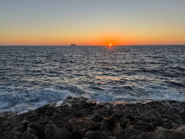 Akdeniz 'de gün batımında Malta' da uzak bir ada görülür.