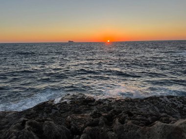 Akdeniz 'de gün batımında Malta' da uzak bir ada görülür.