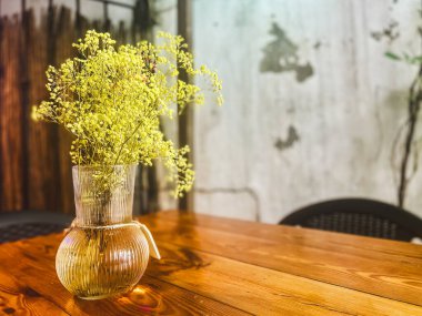 İç tasarımın bir parçası olarak büyük yeşil bir vazoda suni kuru renkli çiçekler.