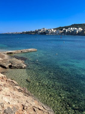 Güneşli bir günde Malta 'nın Bugibba kentinde sahil ve gezinti.