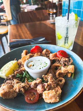 Limonlu kızarmış deniz ürünleri, ekşi krema ve yeşil domatesli ve mayonezli.