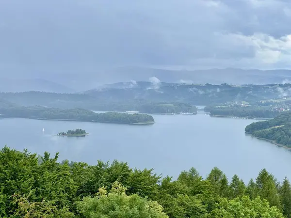 stock image Lake Solina is a largest in Poland water reservoir surrounded by a characteristic landscape of mountains covered with forest and plenty of beaches with tourist infrastructure.