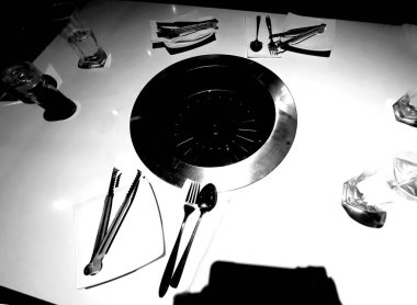 Bir restoranda sofra takımı ve çatal bıçak takımı, siyah ve beyaz.