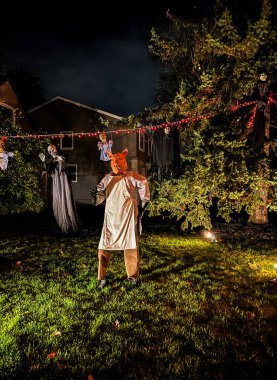Geceleri bahçede çelenkler ve ışıklarla korkuluk. Cadılar Bayramı konsepti Seçici odak.