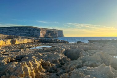 Gozo adasının kayalık sahillerinde güzel bir gün batımı, Malta