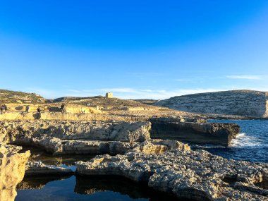 Gozo adasının kayalık sahillerinde güzel bir gün batımı, Malta