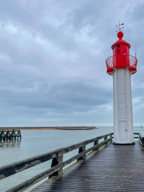Fransa 'nın Normandiya şehrinde, üzerinde mavi gökyüzü ve yağmurlu bulutlar bulunan kırmızı deniz feneri.. 