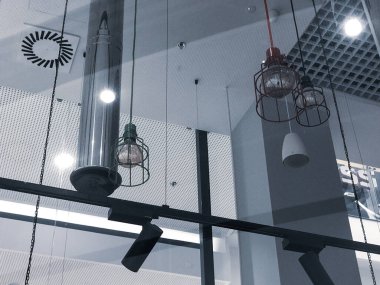 Tavan lambaları ve lambaları olan modern bir ofis binasının iç manzarası. Alışveriş merkezinin modern cam tavanı. Siyah beyaz fotoğraf.