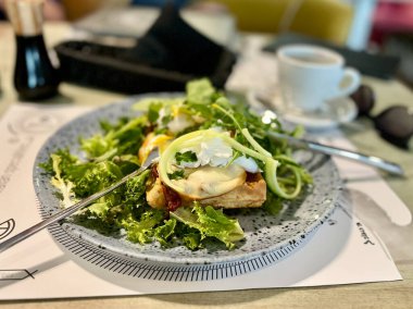 Fırında yumurta ve kızarmış ekmek ile yeşil salata ve restoranda mozzarella peyniri..