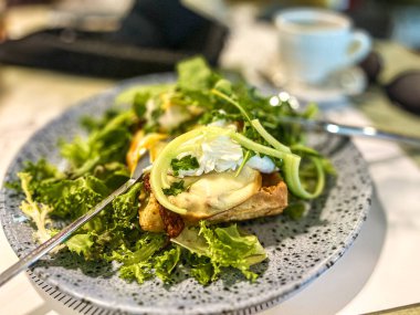 Fırında yumurta ve kızarmış ekmek ile yeşil salata ve restoranda mozzarella peyniri..