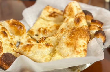 Fırındaki masanın üzerindeki el yapımı pergament kağıdında pişmiş pita ekmeği..