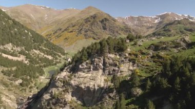 Antik Manastır Vall De Nuria, insansız hava aracı manzaralı. Drone dağların üzerinden manastıra ve göle doğru uçuyor. Manastırın panoramik manzarası çok güzel gölü olan Vall De Nuria