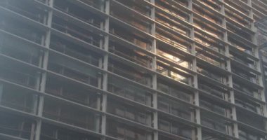 Akşamları ofis binasının önünde güneşin yansıması. Akşamları uzun bir iş merkezinin panoramik manzarası. Güneşli bir günde gökdelen cam cepheleri