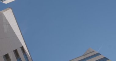 Ofis binasının alt görüntüsü mavi gökyüzü ve uçağın arka planına göre