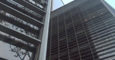 Gün batımı ofis binasının cam cephesine yansıyor. İş, finans ve başarı konularında motive edici bir video için klip