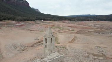 Kuru su deposundaki kilise. Katalonya, İspanya 'daki kurumuş rezervuar Sau. Kuraklık. İklim değişikliği kuraklık kara ve su rezervuarında, insansız hava aracı görünümü