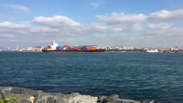 一艘装载集装箱的大船驶经土耳其伊斯坦布尔的金角湾和博斯普鲁斯海峡驶向港口 船离得很远 慢慢地在冷水中穿行 — 图库视频影像