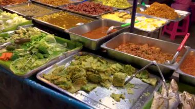 5 Mart 2022. The epprasit Night Market, Pattaya Tayland. En büyük sokak yemekleri satıcılarından birinin sunduğu farklı yemeklere bakarak zaman aşımı.