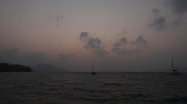 1 Şubat 2024 - Rawai, Phuket Tayland. Güneşin doğuşu iskeleden seyredildi. Yelkenliler suya demir attı..