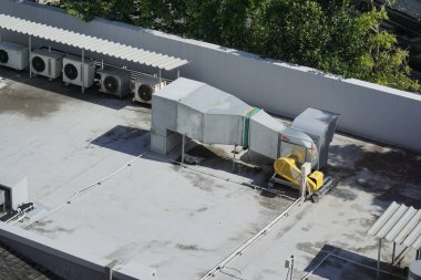 Sarı pervane bir binanın çatısına monte edilmiştir. Vantilatör çatının ortasına yerleştirildi ve diğer pervaneler tarafından çevrildi. Taraftarlar muhtemelen binanın havalandırma sisteminin bir parçası.