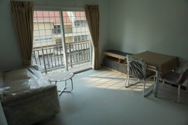 Masası ve sandalyeleri olan küçük, boş bir daire. Oda çok temiz ve boş. Masa plastikle kaplı ve sandalyeler de plastikle kaplı.