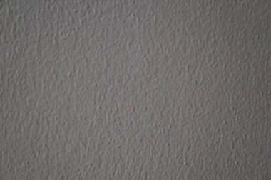 Gri bir dokusu olan duvar. Duvar çok sade ve dekorasyonu yok. Duvar çok pürüzsüz ve çıkıntısı veya çıkıntısı yok.