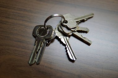 Bir sürü anahtar bir masanın üzerinde yatıyor. Anahtarlar gümüşten ve eski gibi görünüyor.