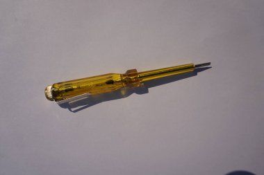 Üzerinde kalem olan sarı elektrikli bir alet. Kalem kullanımda değil. Araç beyaz bir yüzey üzerinde oturuyor