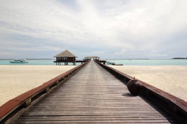 Tekne rıhtımı ve küçük bir kulübesi olan ahşap iskele. İskele uzun ve dar, su da sakin.