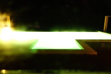 Üzerinde yeşil ışık olan havuz. Havuz aydınlandı ve su yeşil.