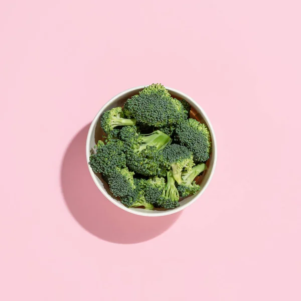 Pastel Pembe Arka Planda Gölgeli Bir Fincan Çiğ Brokoli Minimum — Stok fotoğraf