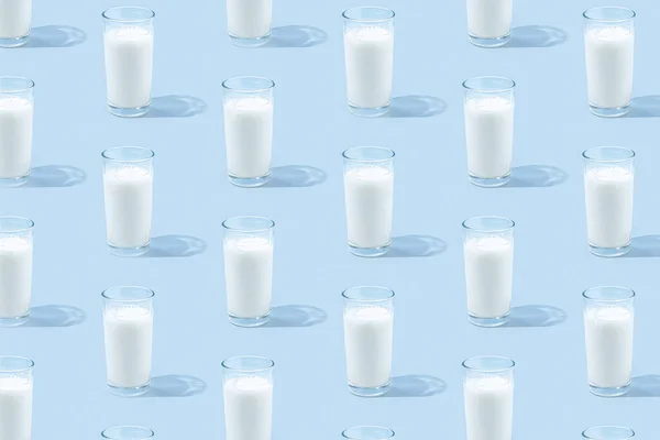 淡蓝色背景上的牛奶杯 有阴影和阳光反射 食物概念 天然饮料的质地 钙和维生素的乳制品来源 最低健康饮料模式 — 图库照片
